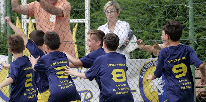 若いサッカー選手とコーチがFestival Scuole Calcio Mirabilandiaで勝利を祝う