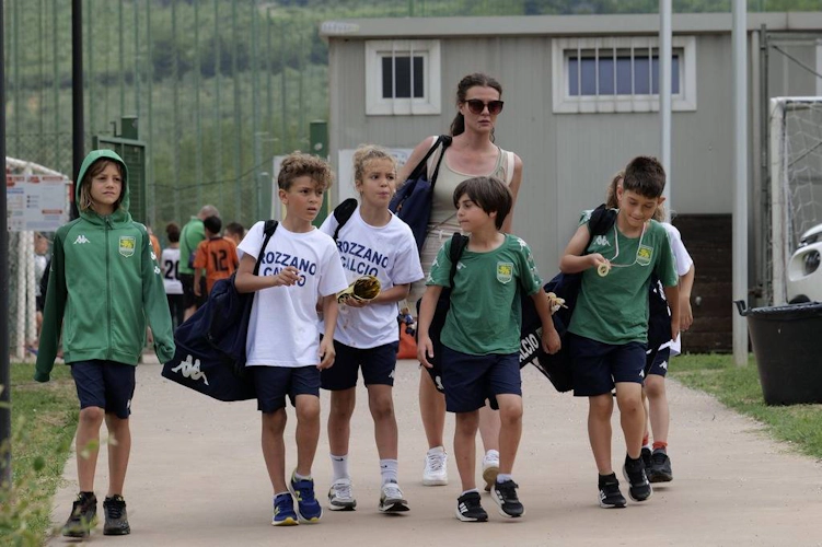 Παιδιά με ποδοσφαιρική ενδυμασία περπατούν με τον προπονητή τους μετά το παιχνίδι
