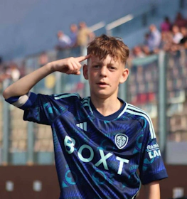 Młody piłkarz salutuje przed trybunami na turnieju U11 KHS Cup