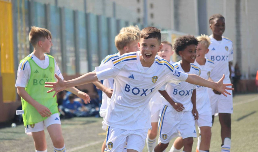 Niños del equipo de fútbol U11 celebran un gol