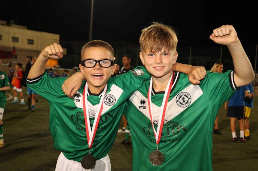 U13 KHSカップのメダルを獲得した若いサッカー選手