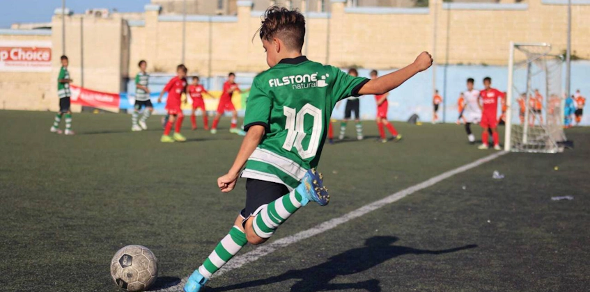 14세 이하 KHS 컵 대회에서 공을 차는 10번 녹색 유니폼의 청소년 선수
