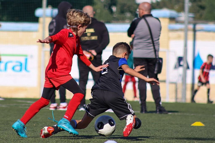 U10 boys competing for the ball in a soccer match