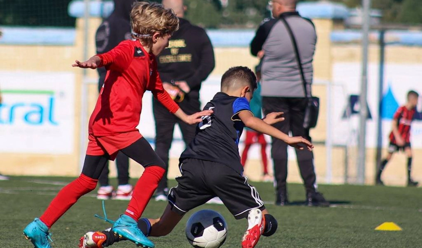 U10 çocuklar futbol maçında top için mücadele ediyor