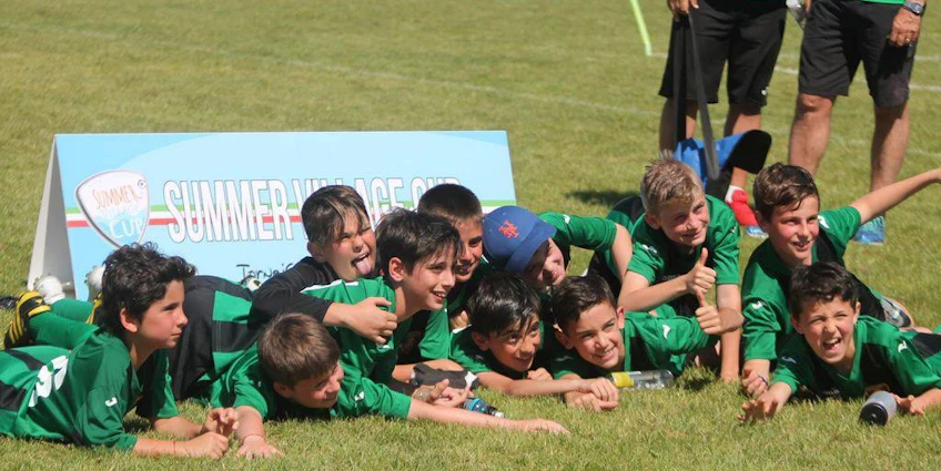 グリーンのユニフォームを着た若いサッカー選手がサマービレッジカップでの勝利を祝う