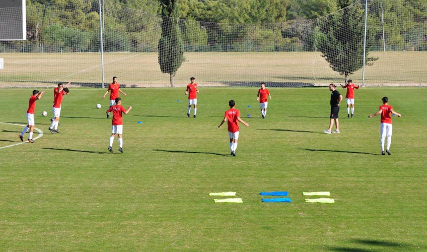 Youth soccer team practicing on a sunny field in Antalya