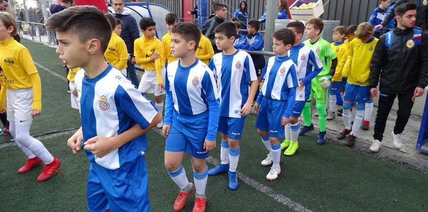 Torneo Promises futbol turnuvasında üniformalı genç futbolcular