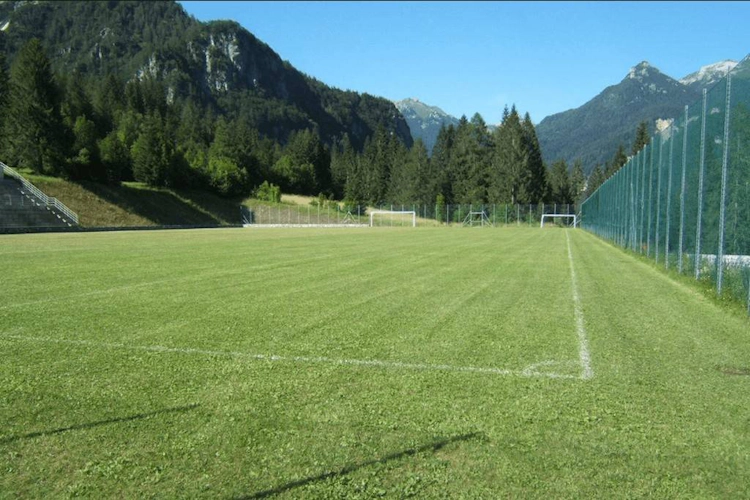 Dolomiterna fotbollsplan med bergslandskap i bakgrunden