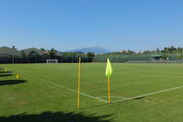 Üres futballpálya a Grand Prix Veronello Summer Trophy tornán, háttérben zölddel és hegyekkel.