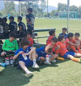 Jóvenes futbolistas descansando en un banquillo en el torneo Alijó Cup