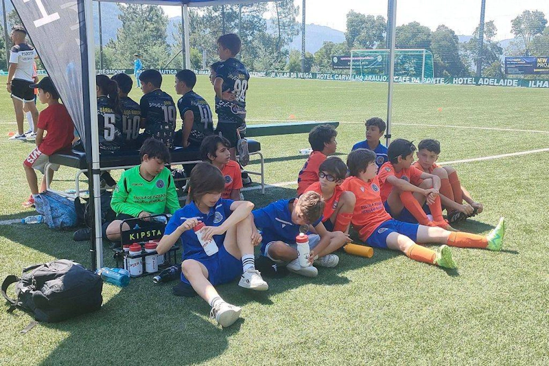 Young football players resting on a bench at the Alijó Cup tournament