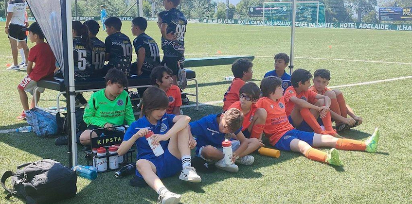 Дети-футболисты отдыхают на скамейке во время футбольного турнира Alijó Cup