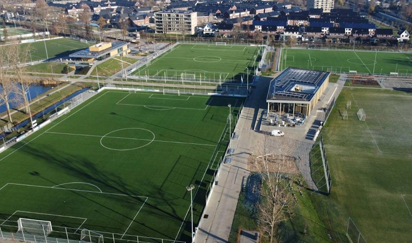 Voetbalvelden met een modern gebouw voor het Hermes DVS International Youth Cup-toernooi