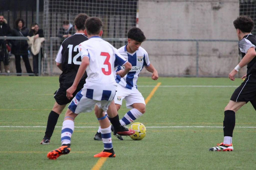 Players fighting for the ball on the field at the U15 Madrid Youth Cup Summer football tournament.
