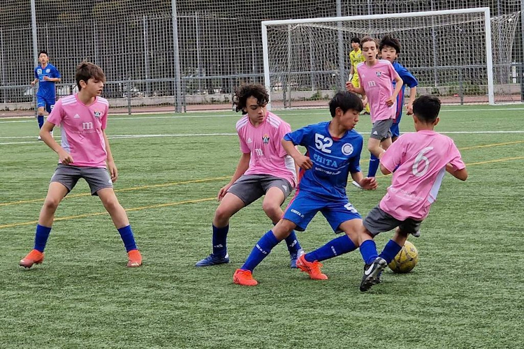 Spillere som konkurrerer om ballen på U15 Madrid Youth Cup på en grønn bane