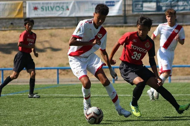 Fußballspiel beim U18 Madrid Youth Cup Summer Turnier, Spieler in roten und weißen Uniformen kämpfen um den Ball.