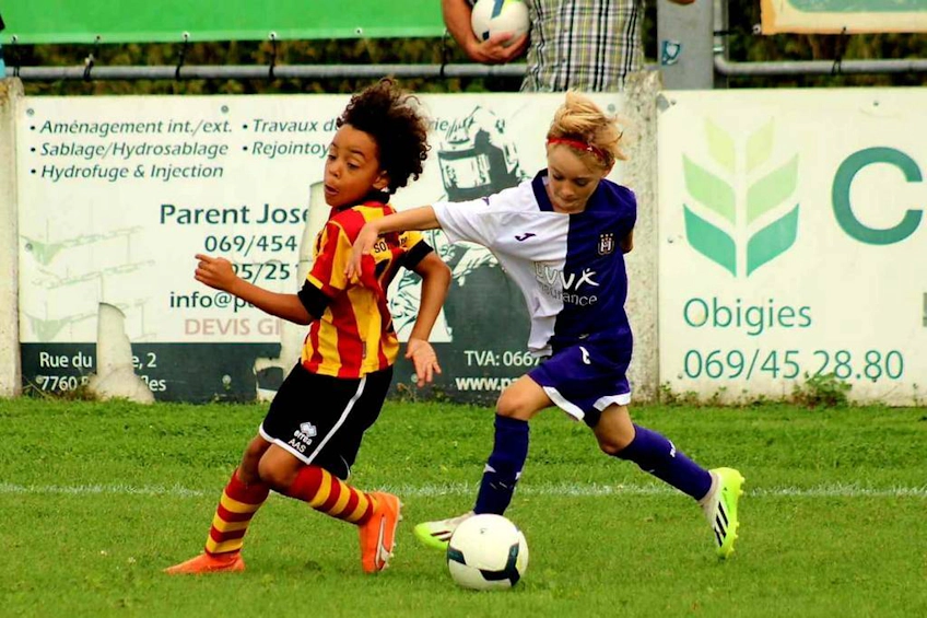 Dzieci walczą o piłkę na boisku podczas turnieju Dufour International Cup.
