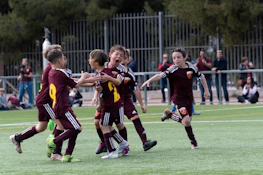 Young footballers celebrate a goal at the Madrid Youth Cup Summer tournament