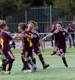 Young footballers celebrate a goal at the Madrid Youth Cup Summer tournament