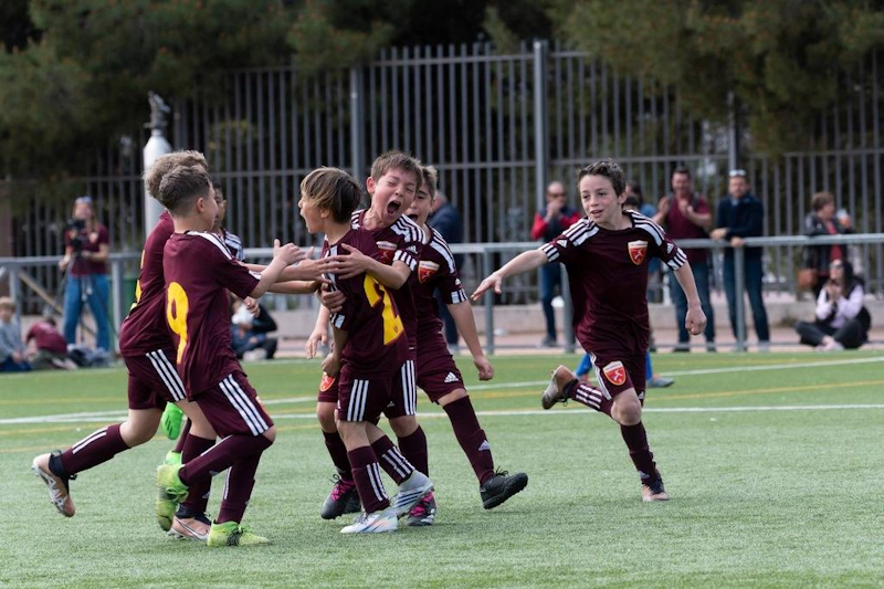 Unge fotballspillere feirer et mål på Madrid Youth Cup sommerturnering