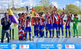 Giovani calciatori in divise a righe rosse e bianche celebrano la vittoria con un trofeo al torneo di calcio ÍscarCup.