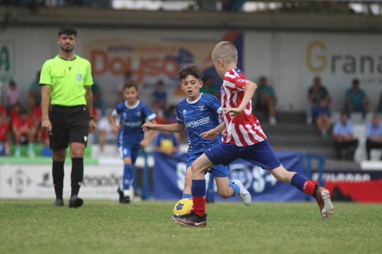 Unga fotbollsspelare som tävlar om bollen på den gröna planen vid ÍscarCup Vilanova-turneringen